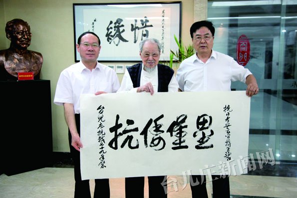 蒋思豫(中)赠送台儿庄大战纪念馆墨宝,右为其子蒋可煌,左为馆长王祥